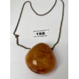 Baltic amber pendant on metal chain, w: 33 grams. Length of pendant 2”