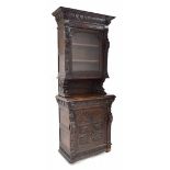 Tall 19th century carved oak Flemish style display cabinet, profusely decorated with masks and