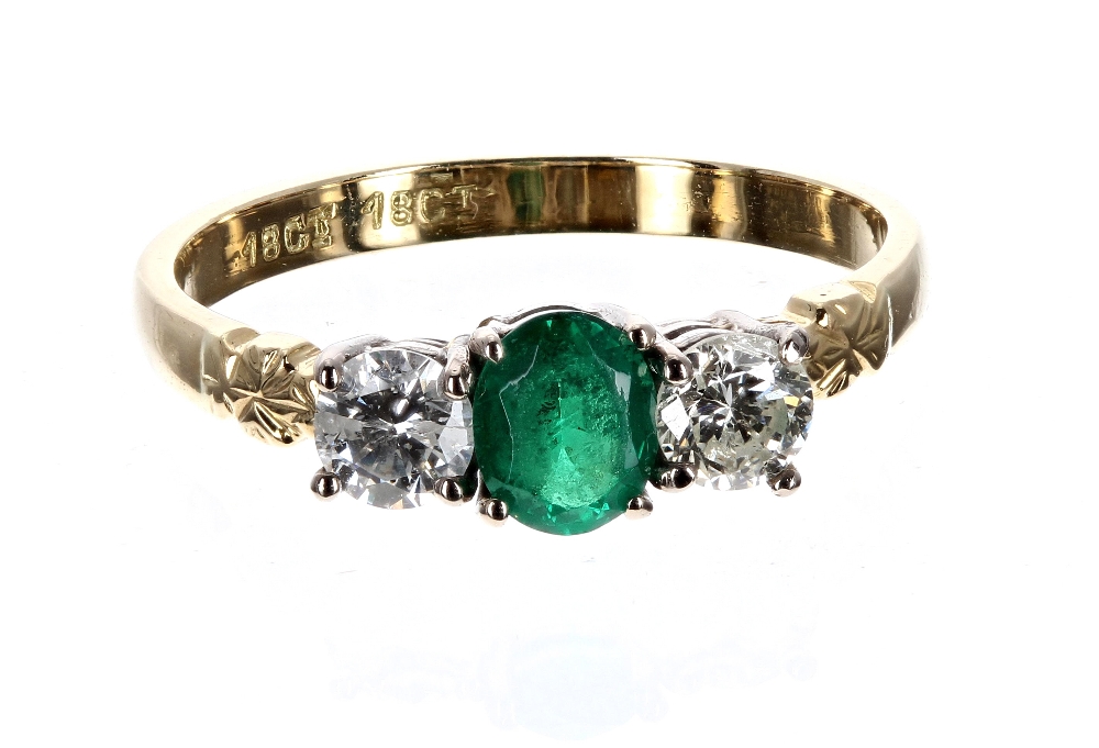 18ct emerald and diamond three stone ring, with an oval emerald flanked with two round brilliant-cut