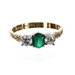18ct emerald and diamond three stone ring, with an oval emerald flanked with two round brilliant-cut