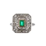 Platinum, emerald and diamond cluster Art Deco style ring, the emerald 0.32ct approx, within a