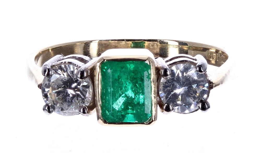 18ct emerald and diamond three stone ring, the centred emerald .70ct, with round brilliant-cut