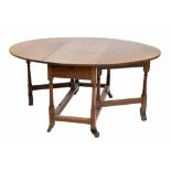 Antique oval gateleg dining table, with a single frieze drawer upon tapered ring turned supports