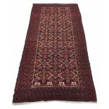 Oriental red ground rug, decorated with central panel of repeated medallions within multiple