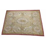 Aubusson type rug, the central oval foliate panel within multiple floral swag borders, on a