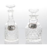 Two similar cut glass decanters with stoppers, the tallest 10" high, one with silver sherry label