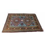 Persian blue ground rug, decorated with twin medallions with flower head motifs around, all within