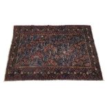 Antique Persian handmade Afshar rug, with repeated foliate motif on a deep blue ground, within