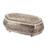 Eastern white metal repousse oval lobed casket, with scrolled foliate decoration upon four ball