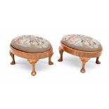 Pair of walnut oval footstools, inset with rose design woolwork panels upon cabriole feet, 14.5"