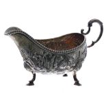 Late Victorian silver sauce boat, repousse decorated with wildlife, flowers and foliage, with C-