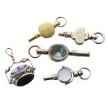 Four gold pocket watch keys, one with an owl seal; also a revolving fob, 8.8gm (5)