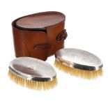 Pair of silver mounted brushes, in leather travel case