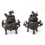 Two similar Japanese bronze incense burners, with figural finial's and twin dragon handles, 19th