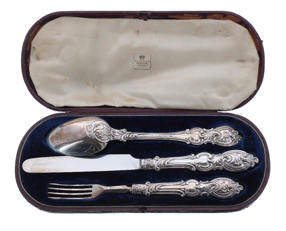 Victorian silver cased christening knife, fork and spoon each with decorative scroll work handle,