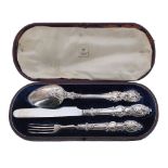 Victorian silver cased christening knife, fork and spoon each with decorative scroll work handle,