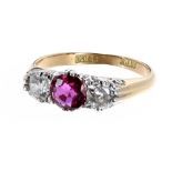 18ct ruby and diamond three stone ring, the central ruby 0.70ct approx, flanked with round