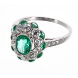 Attractive platinum, emerald and diamond dress ring, set with a central oval shaped emerald,