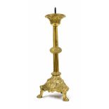 Antique brass ecclesiastical candlestick, raised on a trefoil base with repousse panels of a
