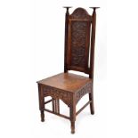 Arts & Crafts carved oak hall chair, the tall arched back with two candle platforms over plain