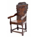 17th century oak wainscot armchair, the rectangular geometric panelled back with a carved cresting