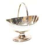 George III silver boat shape bonbon dish, swing handle and foliate engraved border on a pedestal