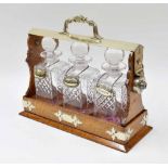 Edwardian oak and silver plate mounted tantalus for three square decanters, with Daniel & Arter