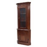 Mahogany glazed standing corner cabinet, the shaped cornice over arched glazed door enclosing a
