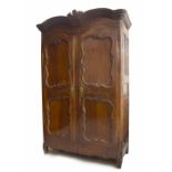 Good early 19th century French oak armoire, with a shaped pediment over panelled doors with brass