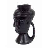 Congolese Kuba carved wine cup, with three typical stylised faces and figural handle, 8.5" high