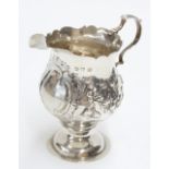 George III silver cream jug with a card cut rim, on a pedestal base, maker NS & AN, London 1768,