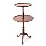 Georgian style mahogany two tier dumb waiter, with piecrust moulded rims, on a turned support raised