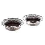 Pair of Elkington & Co. silver plated wine coasters, with shaped wavy rims around turned hardwood