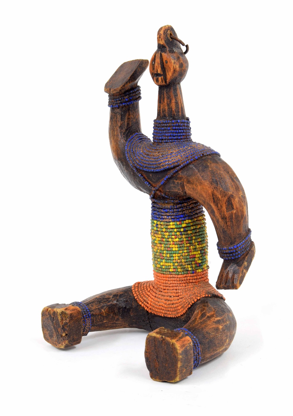 20th century carved Ethiopian Konso figure of a seated gentleman, wearing slim strings of coloured