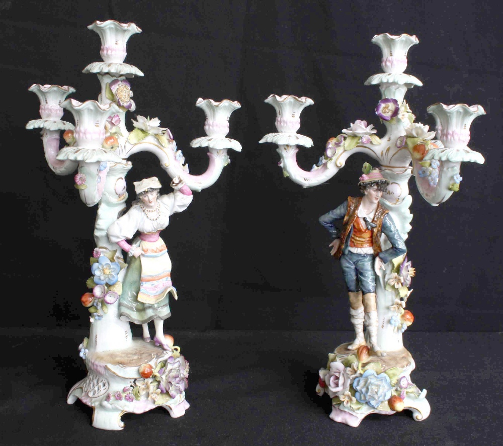 Pair of German figural and floral encrusted porcelain candelabra, late 19th century, featuring a