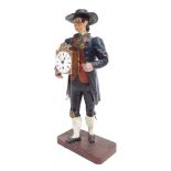 German novelty timepiece modelled as a standing street clock pedlar, holding a timepiece in his