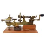 Antique brass and steel turning lathe, upon a later mahogany canted rectangular plinth, 20" wide