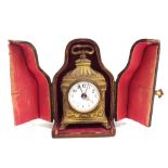 Miniature French gilt metal travelling alarm clock, the 1.5" white dial within an ornate case