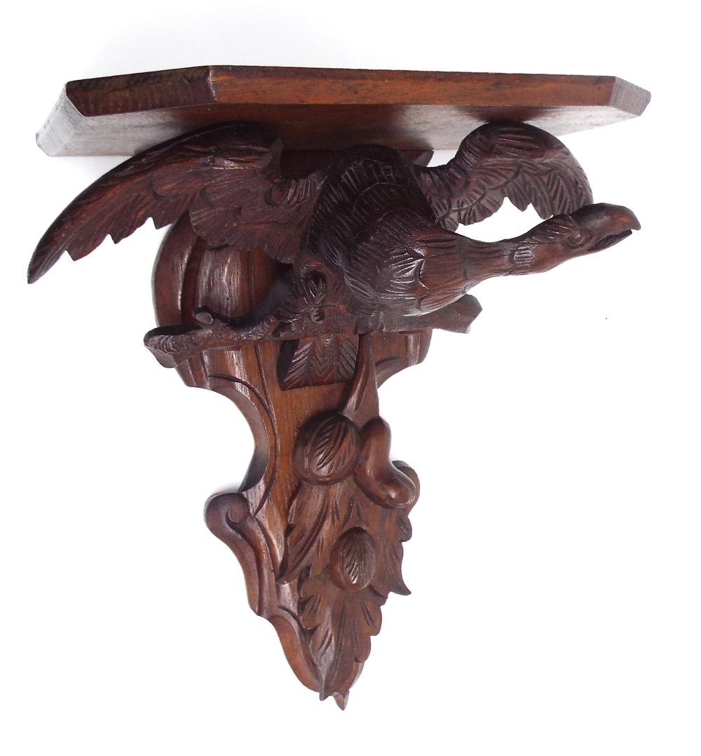 Oak clock wall bracket, carved with an eagle support over fruiting foliage, 12.75" wide, 9" deep
