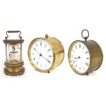 Small cylindrical brass cased ticket clock, surmounted by a carrying handle, 6.5" high (crack to
