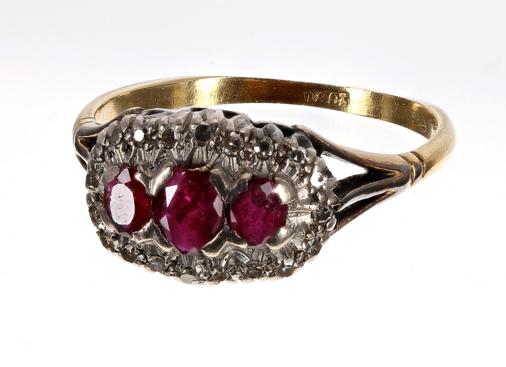 18ct ruby and diamond boat shaped cluster ring, with three oval rubies in a diamond claw setting,