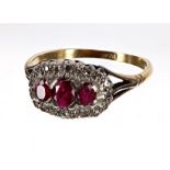18ct ruby and diamond boat shaped cluster ring, with three oval rubies in a diamond claw setting,