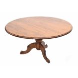 Circular pine pedestal table, the moulded top on a turned support and three shaped cabriole legs,