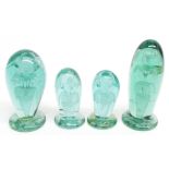 Four similar Nailsea green glass dumps, each internally decorated with flowers, the largest 6.5"