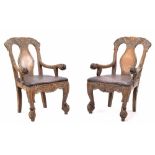 Pair of Burmese carved hardwood hall chairs, the backs with carved opposing dragons over single