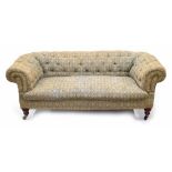 Victorian Chesterfield button upholstered settee, raised on turned front legs terminating on brass