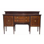 Edwardian mahogany sideboard, the raised blind fret back on a breakfront moulded top, over two short