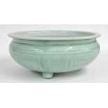 Chinese celadon glazed circular porcelain low jardiniere, decorated with key pattern bands on