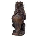 17th century carved oak lion, modelled holding a scrolling shield, 14" high