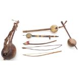 Four various antique and later African and other folk fiddles; together with three various folk